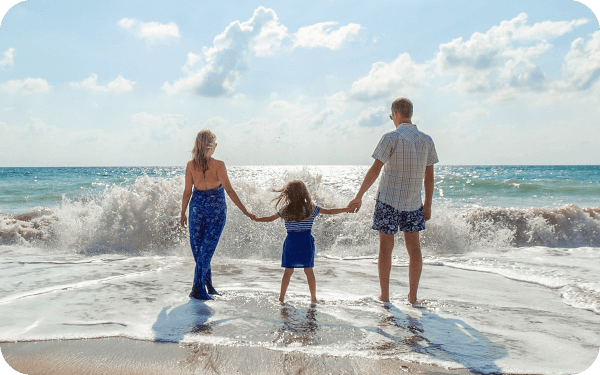 Familia en una playa en una foto de baja resolución. Familia en una playa en una versión ampliada con contornos más definidos.